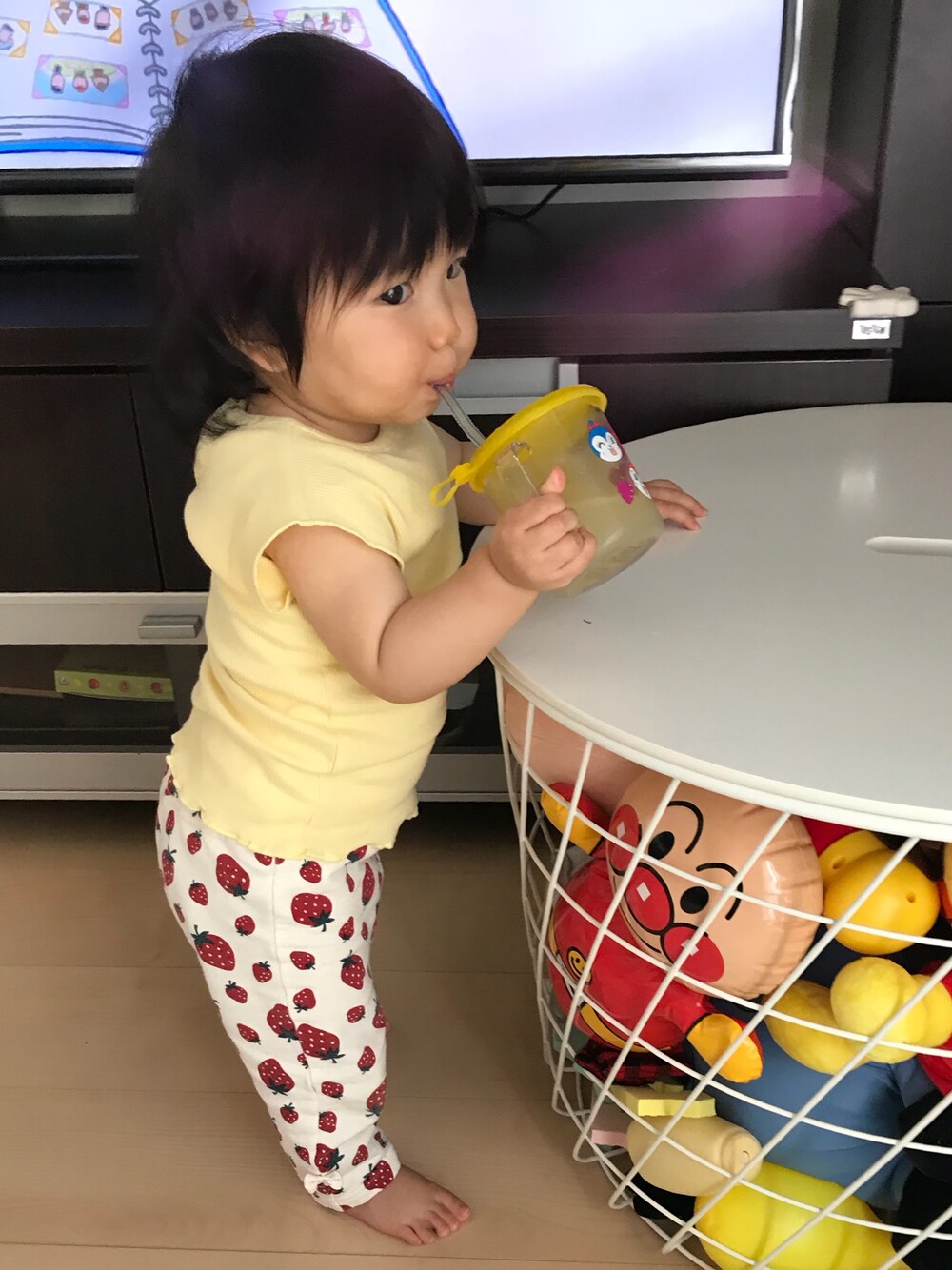 「11ヶ月、ベビーコーデ、ベビー、あかちゃんコーデ、いちご、パッツン前髪、男の子に見えるけど女の子、立って飲むときはつま先立ち」｜「アンパンマンの中身はりんごジュースのアイテム（グラス/マグカップ/タンブラー、ホワイト系）」を使った、えみをさん（キッズ・70cm）の夏コーディネートの1枚目の写真