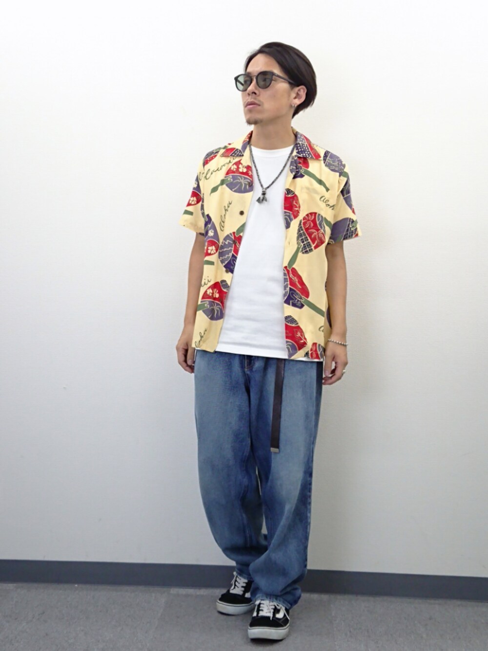 ブラック系のスニーカー、ホワイト系のTシャツ/カットソー、ブルー系のデニムパンツを着用したメンズの夏コーディネートの1枚目の写真