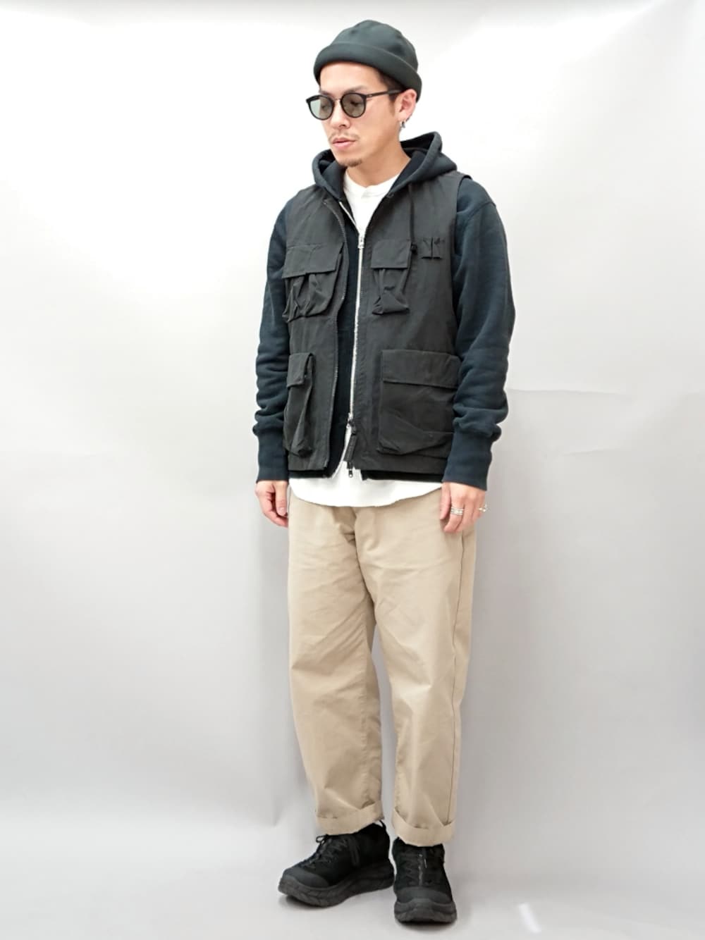 ブラック系のパーカー、ブラック系のその他アウター、ホワイト系のTシャツ/カットソーを着用したメンズの春コーディネートの1枚目の写真