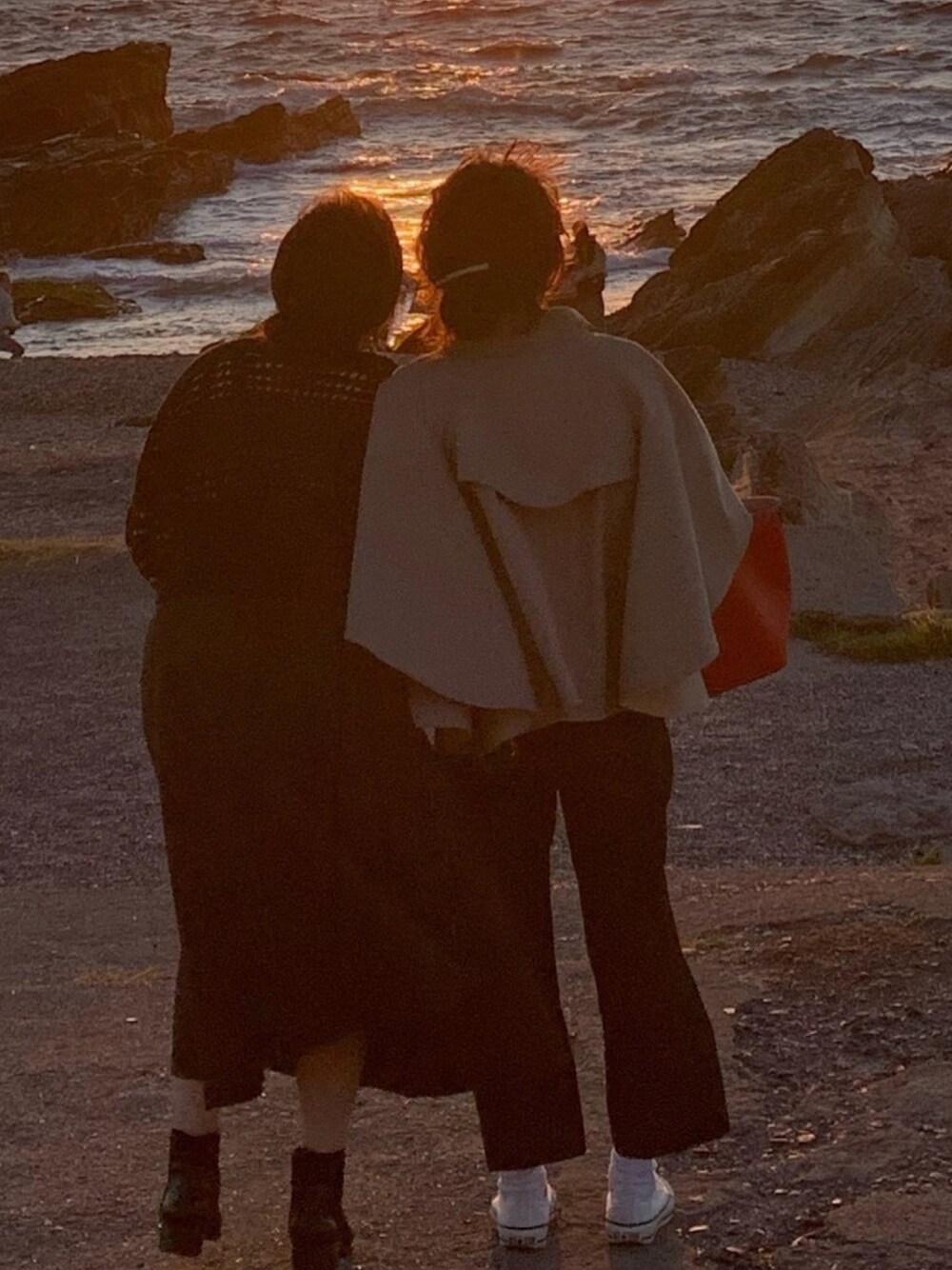 ベージュ系のトレンチコート、ブラック系のパンツ、ホワイト系のスニーカーを着用したレディースの秋コーディネートの1枚目の写真