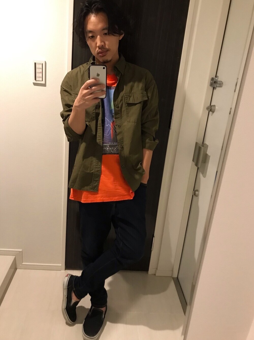 オレンジ系のTシャツ/カットソー、グリーン系のシャツ/ブラウス、ブルー系のデニムパンツを着用したメンズの夏コーディネートの1枚目の写真