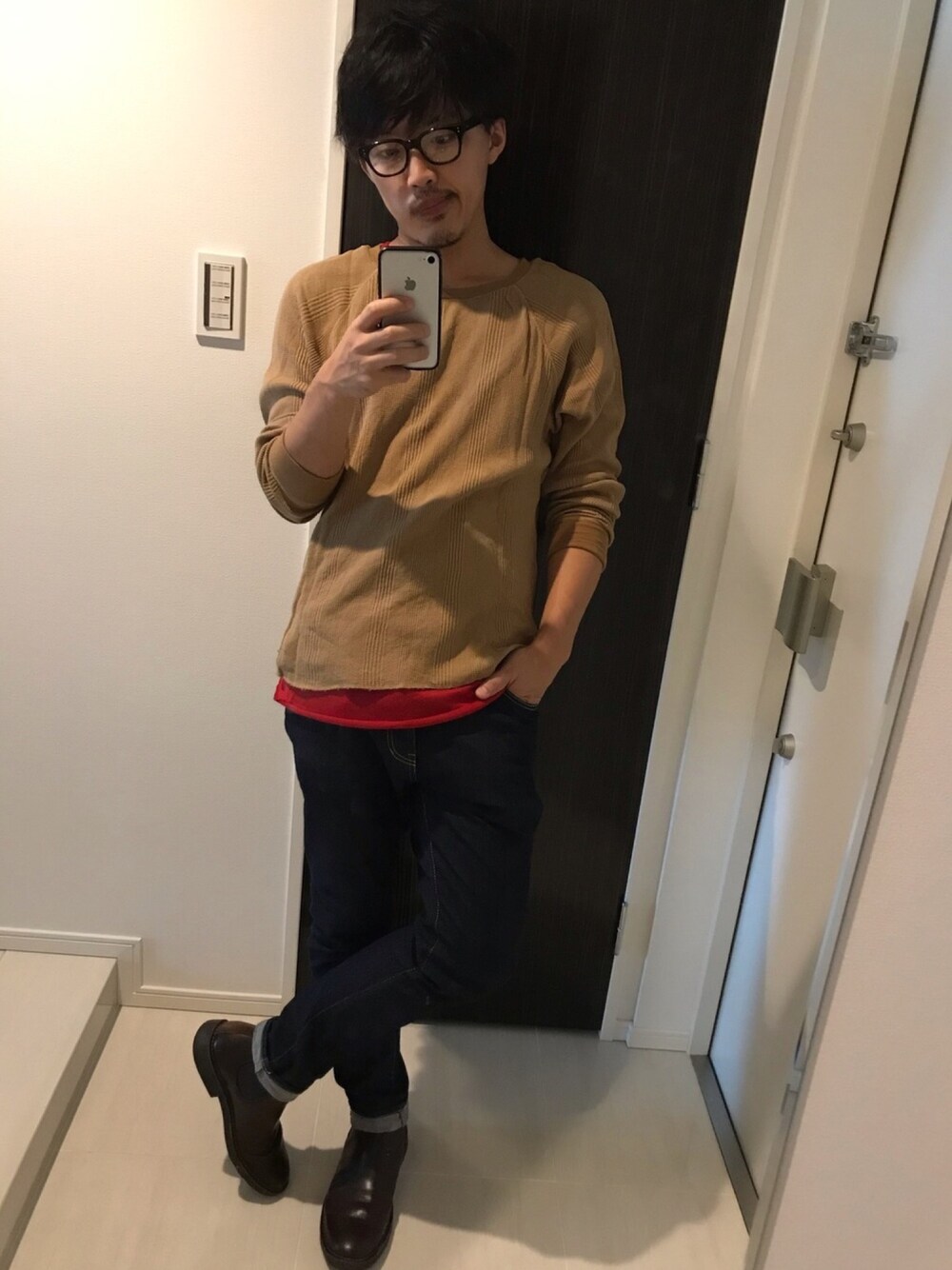 レッド系のタンクトップ、ベージュ系のTシャツ/カットソー、ブルー系のデニムパンツを着用したメンズの秋コーディネートの1枚目の写真