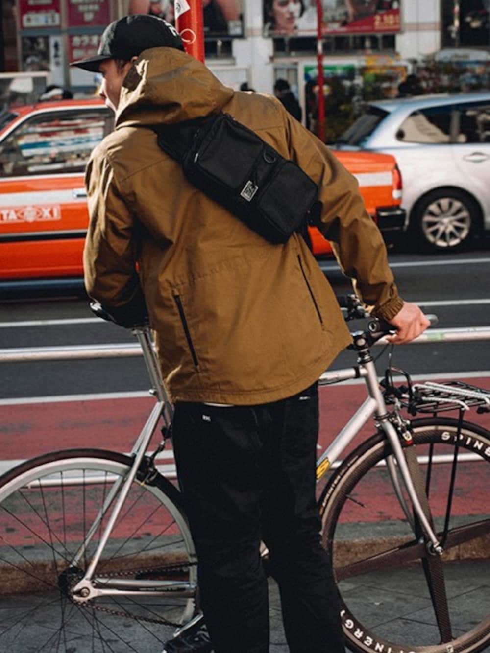 ブラック系のボディバッグ/ウエストポーチを着用したメンズの春コーディネートの1枚目の写真