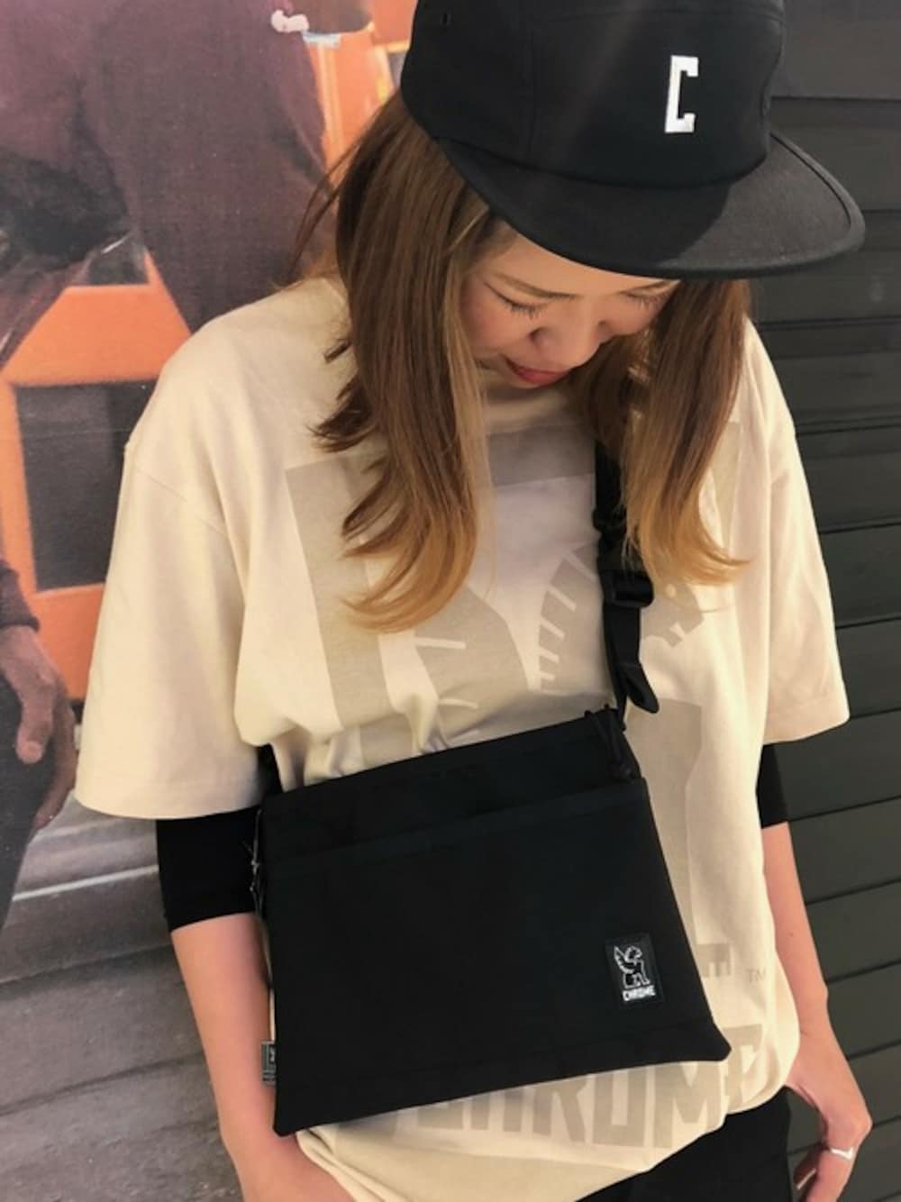 ブラック系のショルダーバッグ、ベージュ系のTシャツ/カットソーを着用したレディースの春コーディネートの1枚目の写真