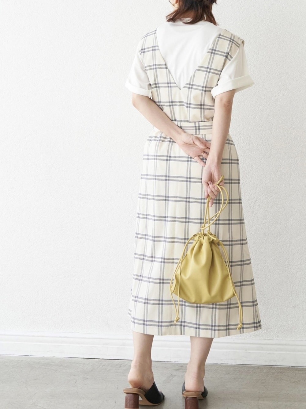 ホワイト系のTシャツ/カットソー、ホワイト系のジャンパースカート、ブラック系のサンダルを着用したレディースの春コーディネートの1枚目の写真