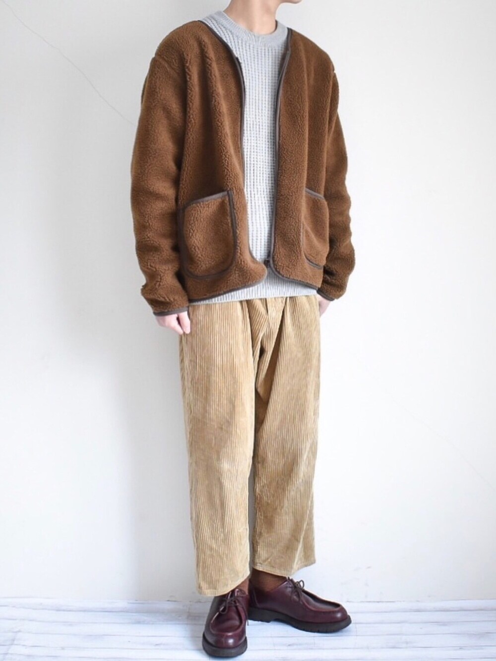 イエロー系のカーディガン/ボレロ、グレー系のニット/セーター、イエロー系のその他パンツを着用したメンズの冬コーディネートの1枚目の写真