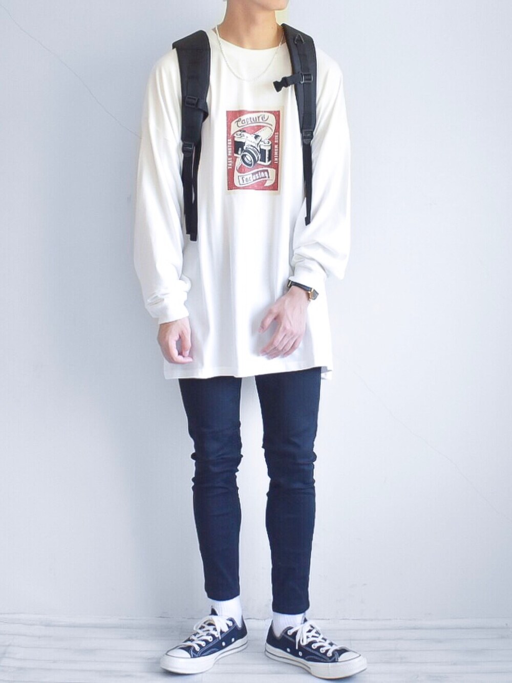 ホワイト系のTシャツ/カットソー、ブラック系のパンツ、ブラック系のバックパック/リュックを着用したメンズの秋コーディネートの1枚目の写真