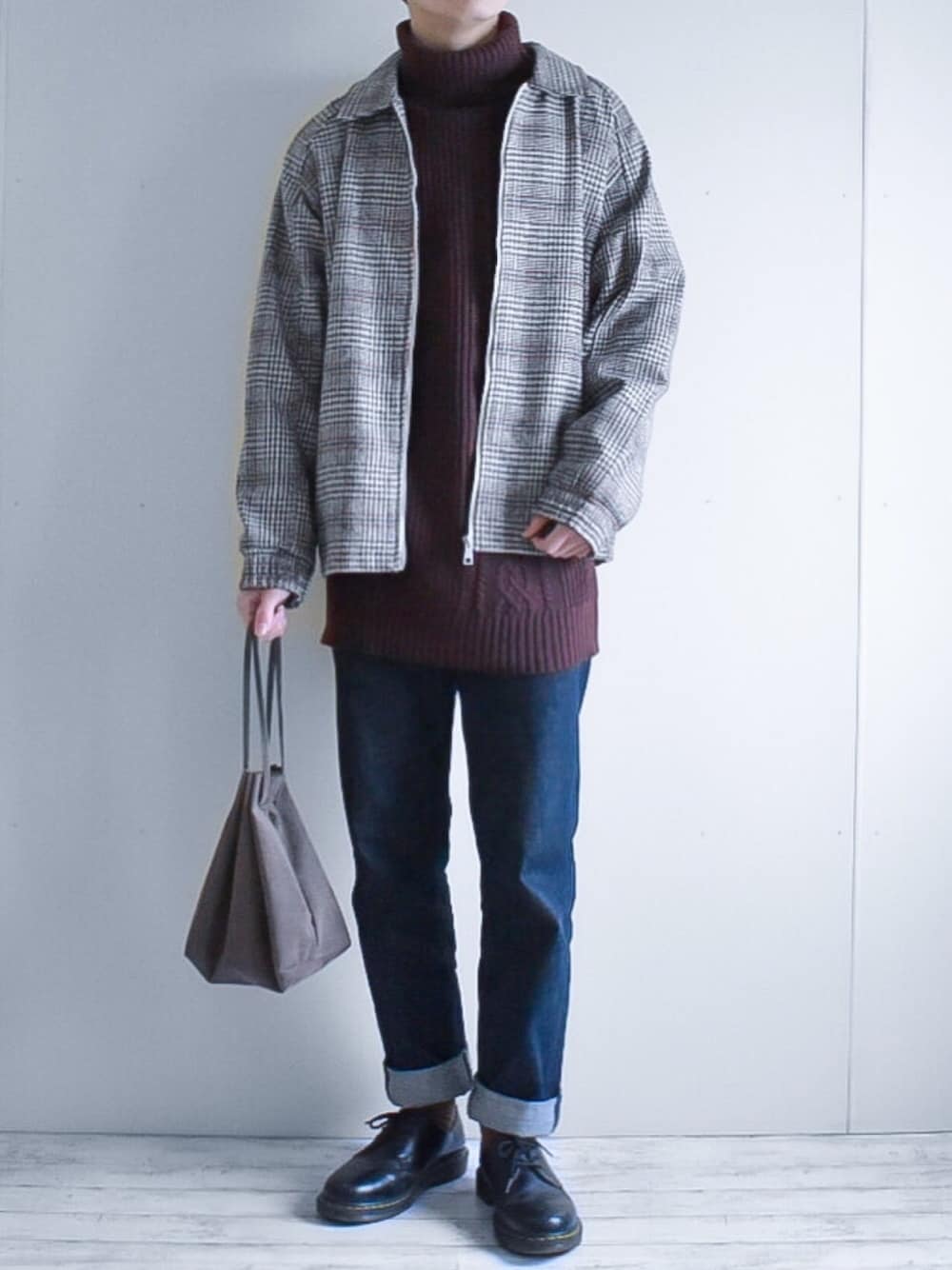 ベージュ系のブルゾン、ブラウン系のニット/セーター、ブルー系のデニムパンツを着用したメンズの冬コーディネートの1枚目の写真
