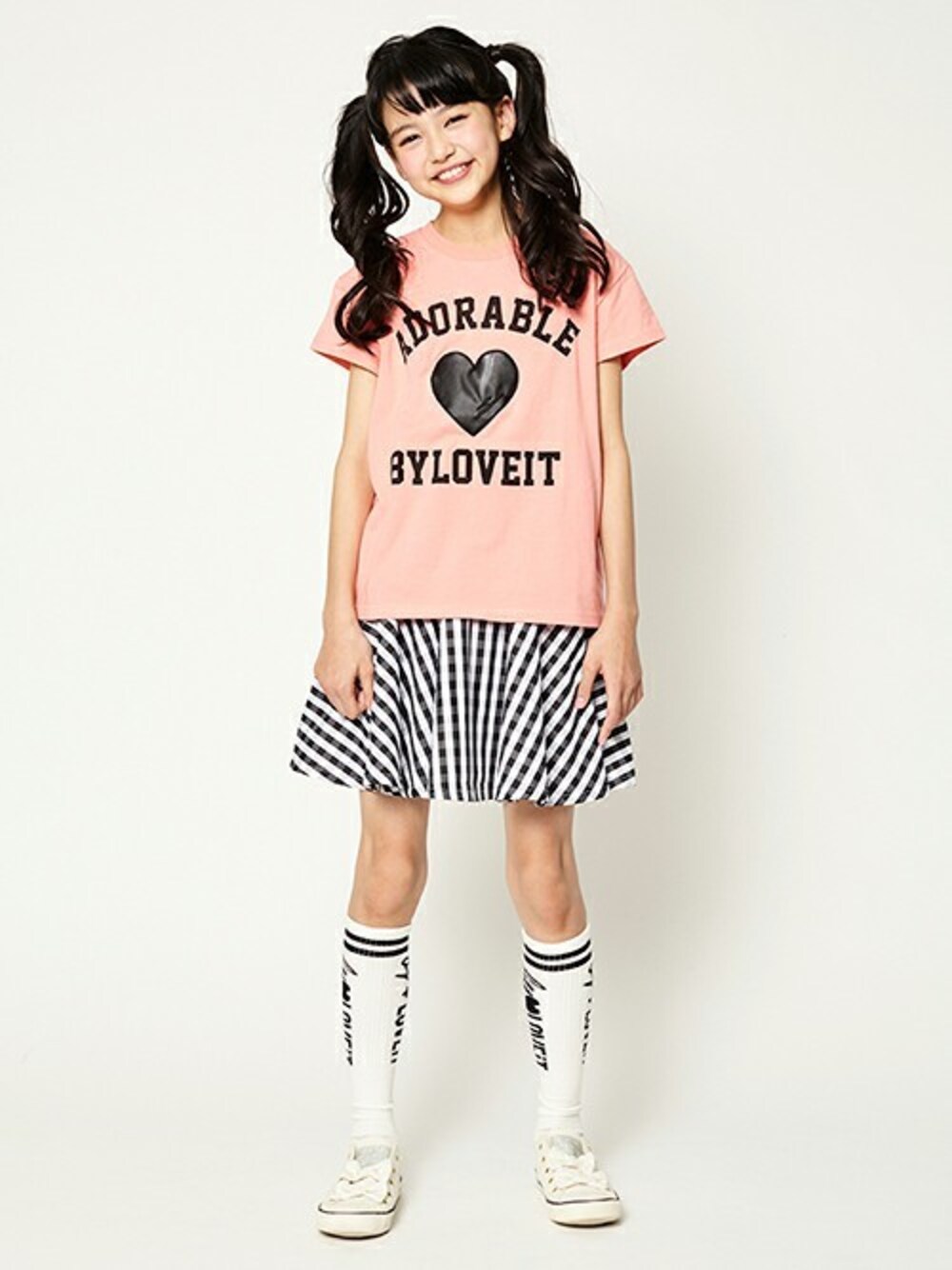 オレンジ系のTシャツ/カットソー、ブラック系のジャンパースカート、ブラック系のソックス/靴下を着用したキッズの冬コーディネートの1枚目の写真