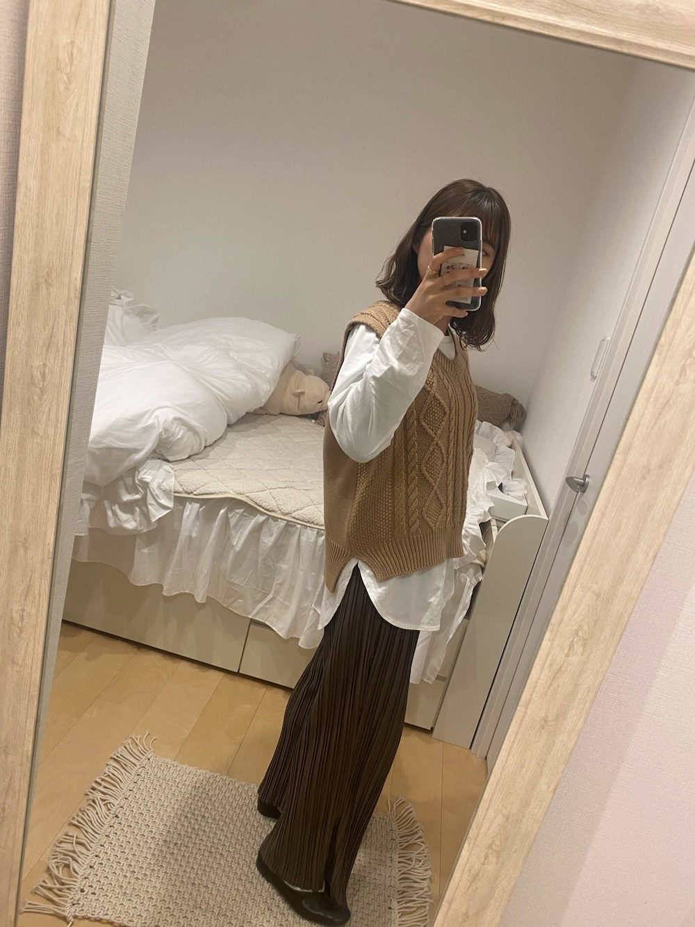 ベージュ系のベスト、ブラウン系のその他パンツ、ホワイト系のTシャツ/カットソーを着用したレディースの冬コーディネートの1枚目の写真