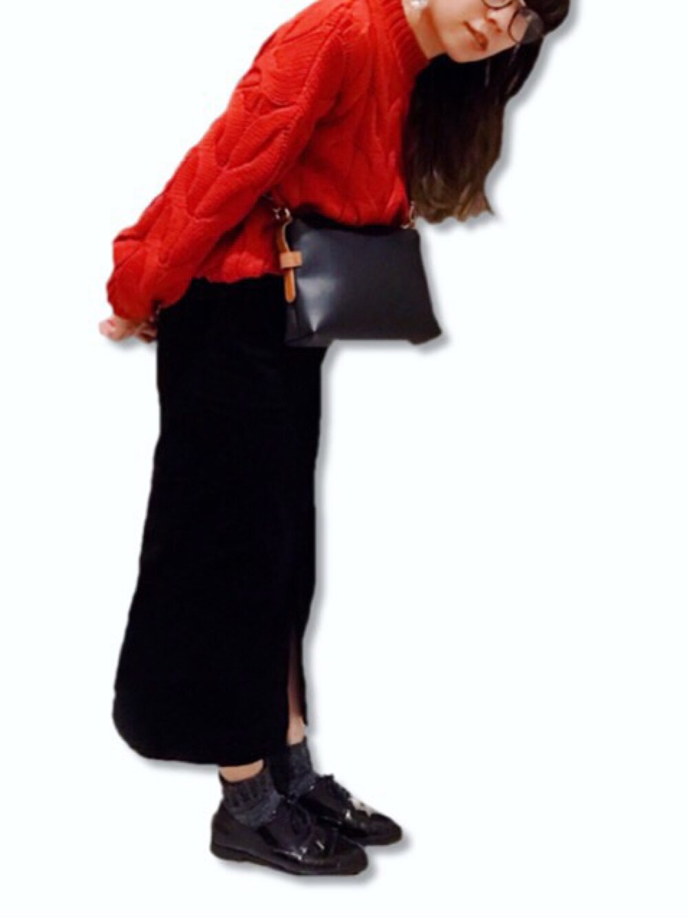 ブラック系のスカート、レッド系のニット/セーター、ブラック系のドレスシューズを着用したレディースの冬コーディネートの1枚目の写真