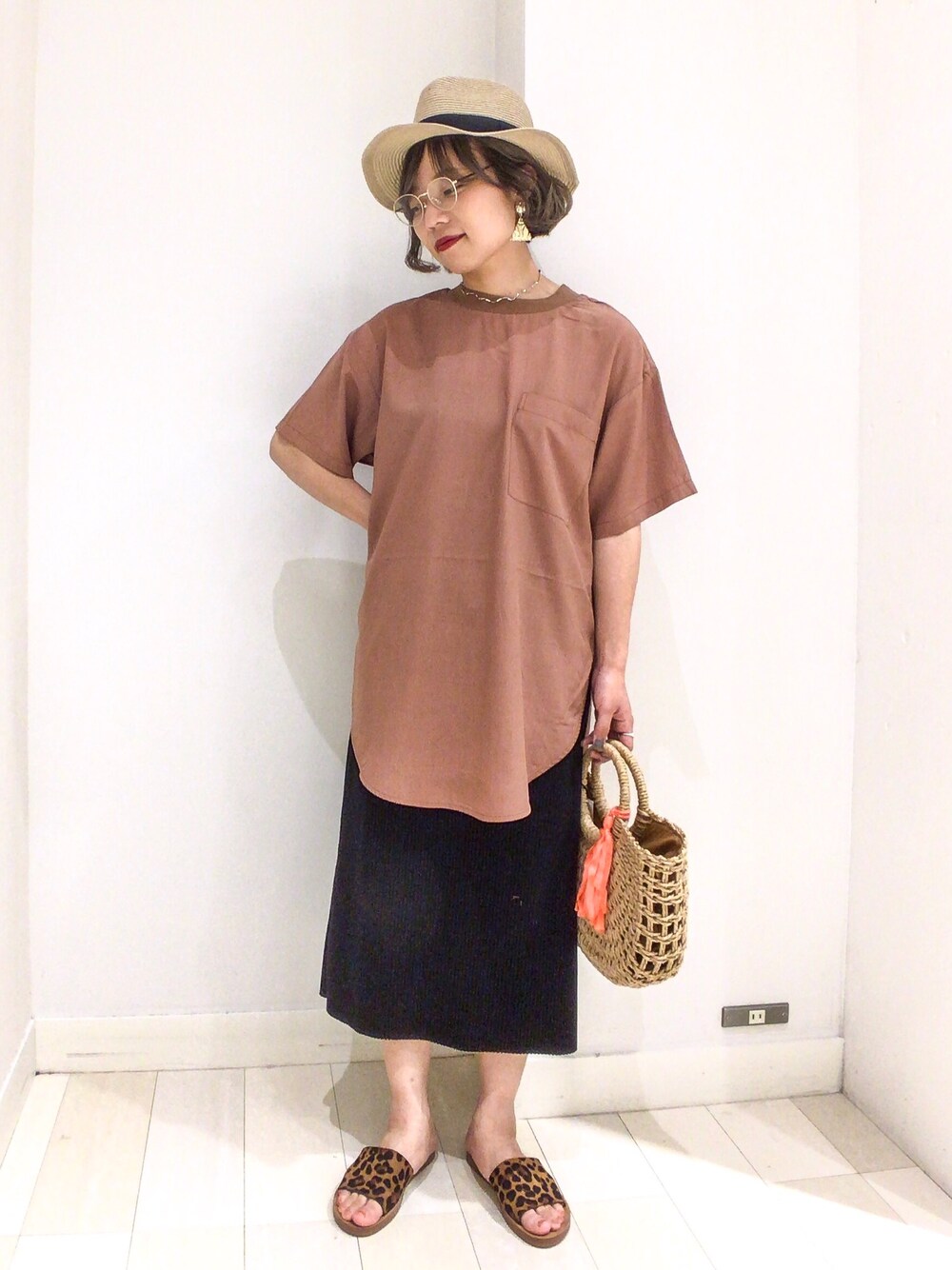 イエロー系のシャツ/ブラウス、ベージュ系のトートバッグ、ブラック系のスカートを着用したレディースの夏コーディネートの1枚目の写真