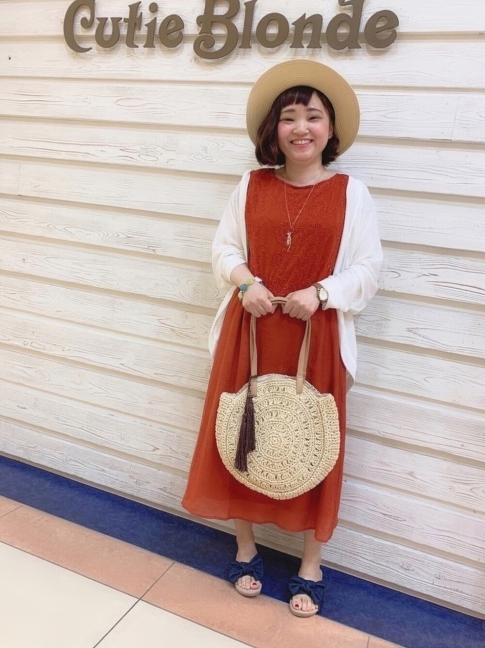 ホワイト系のカーディガン/ボレロ、ベージュ系のトートバッグ、ブルー系のサンダルを着用したレディースの夏コーディネートの1枚目の写真
