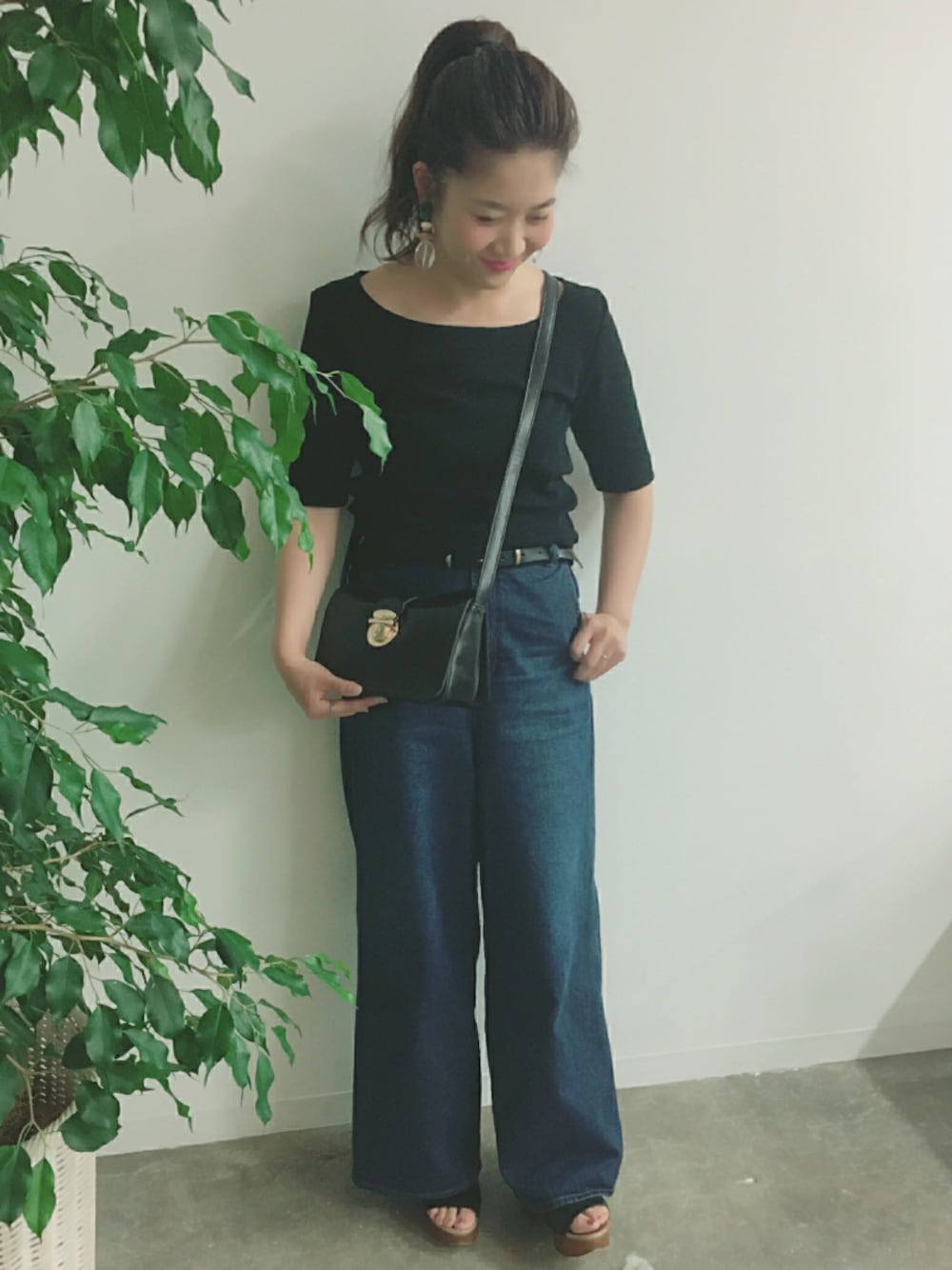 ブラック系のTシャツ/カットソー、ブラック系のショルダーバッグ、ブルー系のデニムパンツを着用したレディースの春コーディネートの1枚目の写真