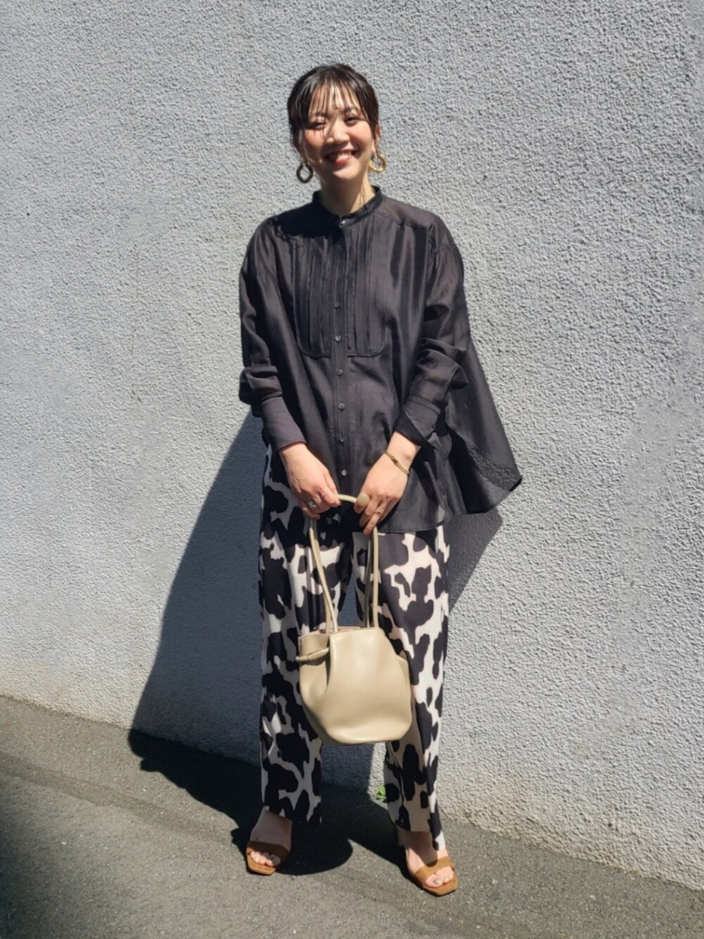 ベージュ系のシューズ、ブラック系のパンツ、ブラック系のシャツ/ブラウスを着用したレディースの春コーディネートの1枚目の写真