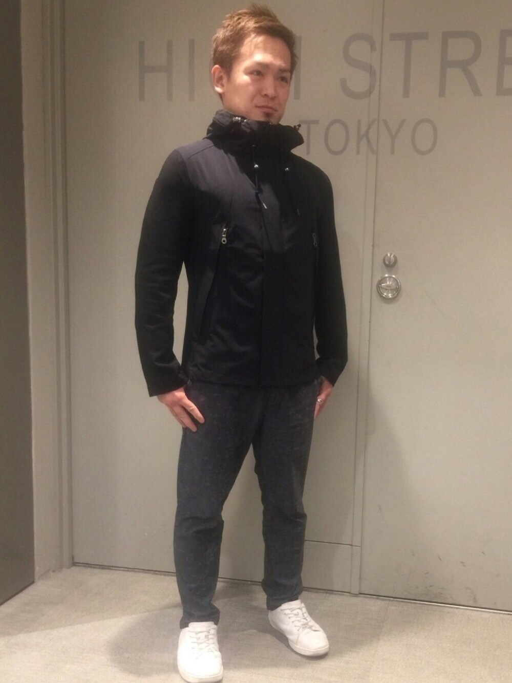 ブラック系のジャケット/アウター、ブルー系のパンツ、ホワイト系のシューズを着用したメンズの春コーディネートの1枚目の写真