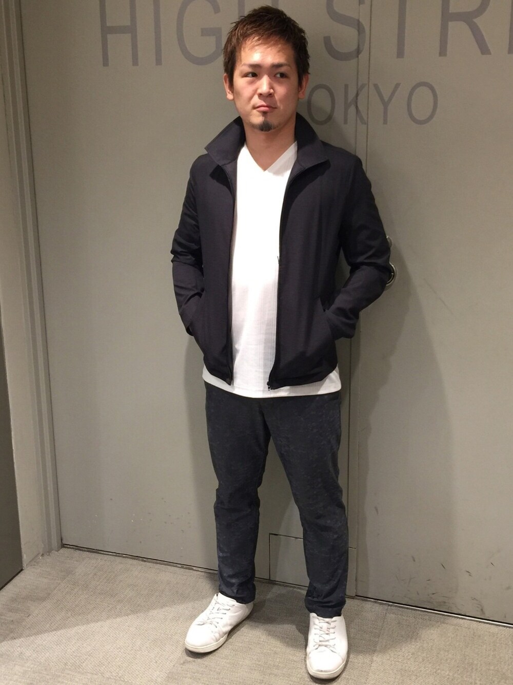 ブラック系のトップス、ホワイト系のトップス、ブルー系のパンツを着用したメンズの春コーディネートの1枚目の写真