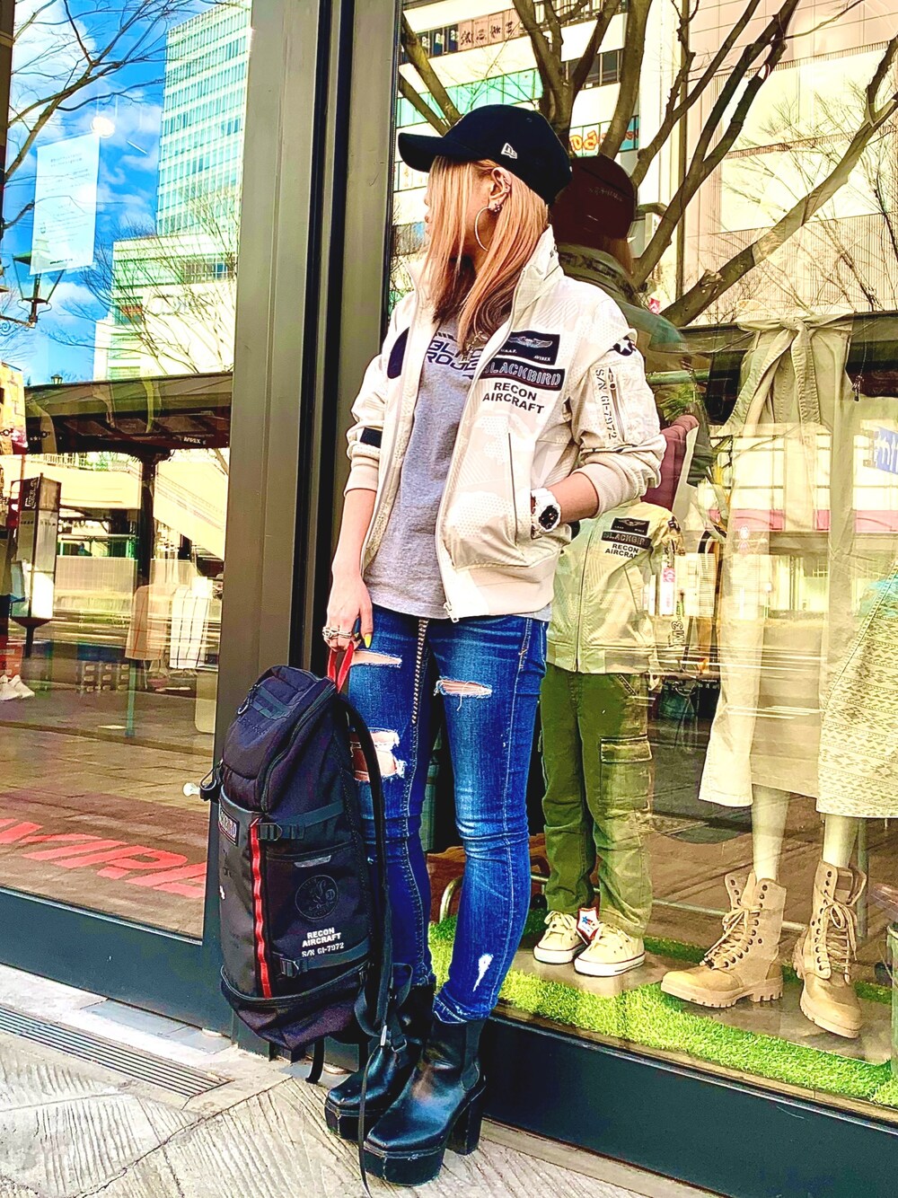 レッド系のミリタリージャケット、グレー系のTシャツ/カットソー、ブラック系のバックパック/リュックを着用したレディースの冬コーディネートの1枚目の写真