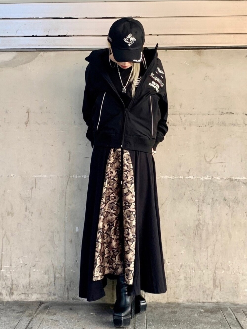 レッド系のミリタリージャケット、ブラック系のTシャツ/カットソー、ブラック系のスカートを着用したレディースの春コーディネートの1枚目の写真