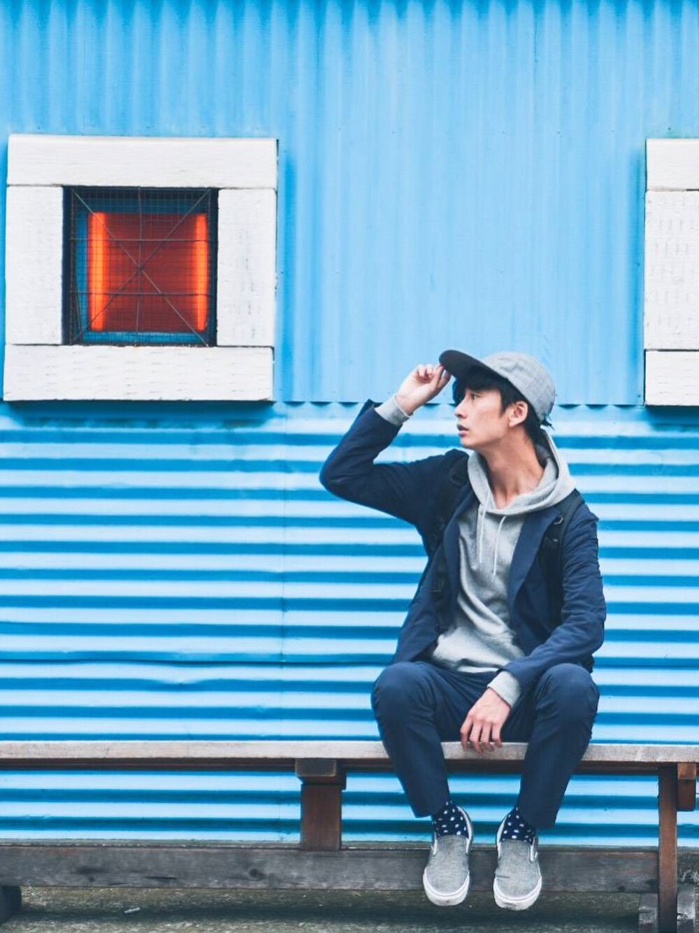 ブルー系のテーラードジャケット、グレー系のパーカー、グレー系のスリッポンを着用したメンズの秋コーディネートの1枚目の写真