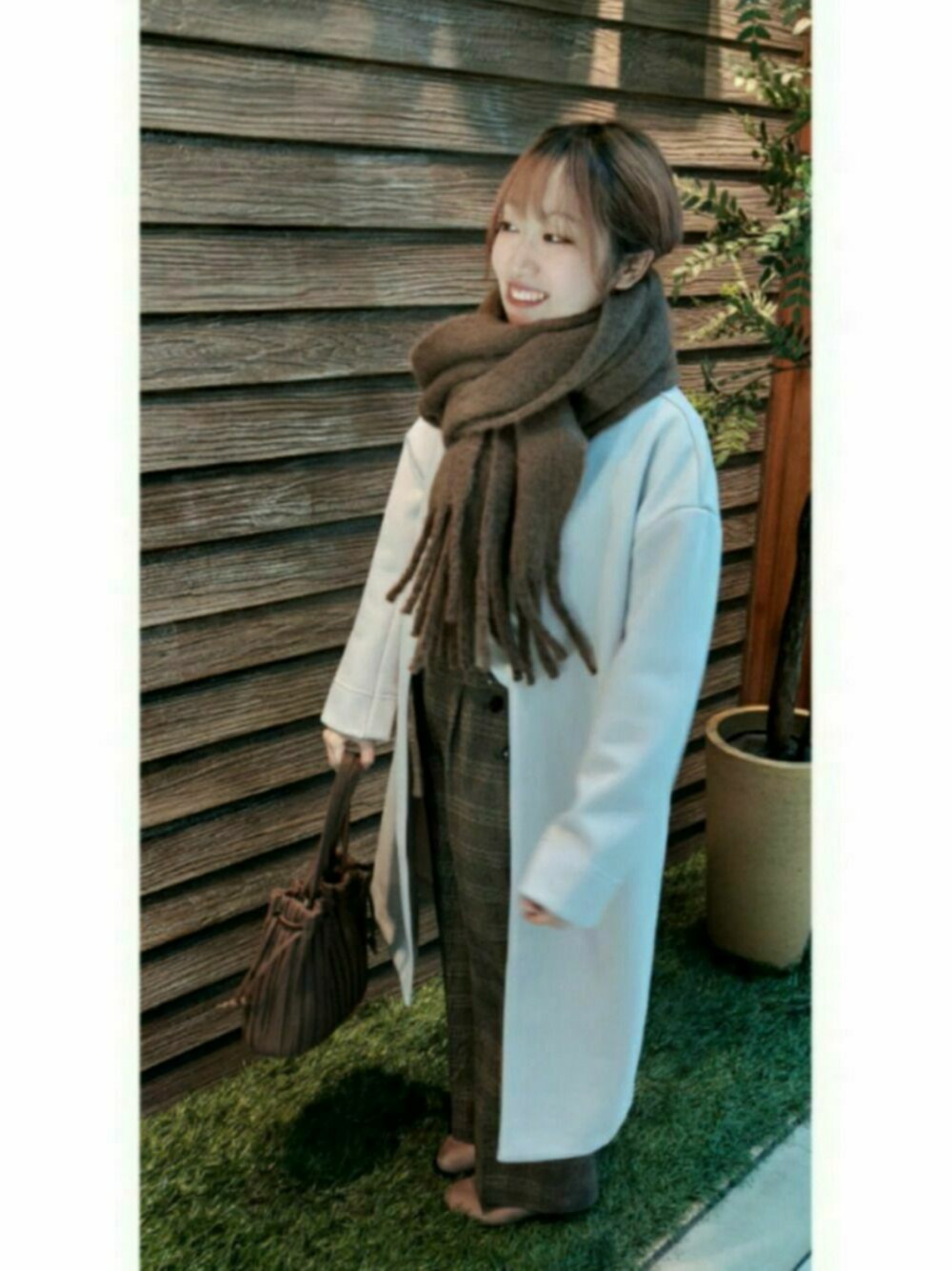ベージュ系のブーツ、ホワイト系のTシャツ/カットソー、ブラウン系のショルダーバッグを着用したレディースの冬コーディネートの1枚目の写真