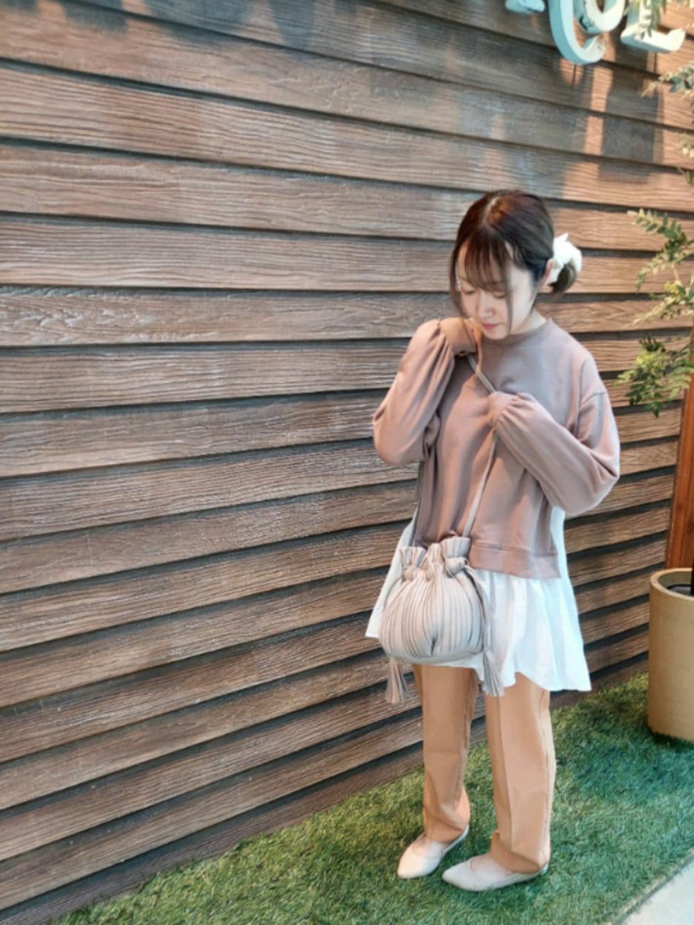 ベージュ系のショルダーバッグ、ホワイト系のその他シューズ、ベージュ系のチュニックを着用したレディースの春コーディネートの1枚目の写真