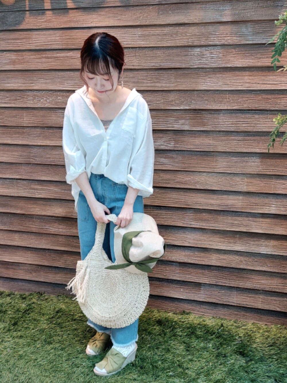 ホワイト系のシャツ/ブラウス、ベージュ系のタンクトップ、ブルー系のデニムパンツを着用したレディースの春コーディネートの1枚目の写真