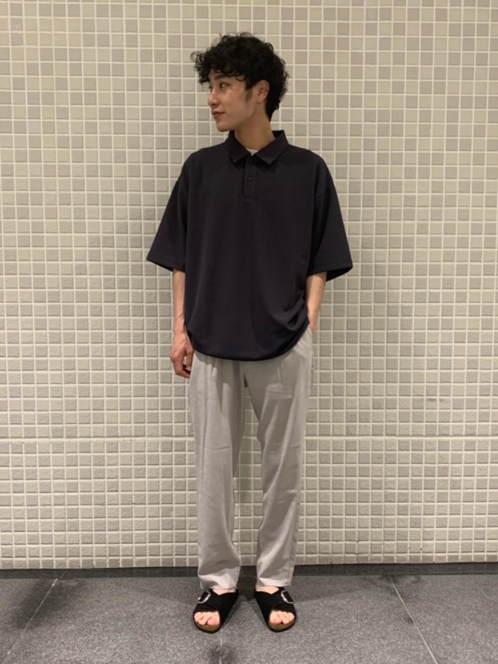 ブラック系のサンダル、グレー系のポロシャツ、ベージュ系のその他パンツを着用したメンズの春コーディネートの1枚目の写真