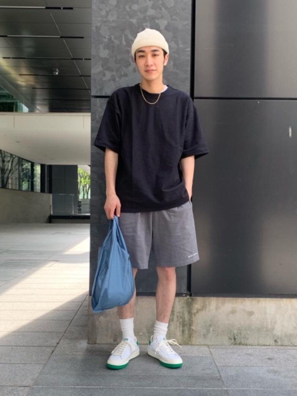 ブラック系のTシャツ/カットソー、ブルー系のトートバッグ、グリーン系のスニーカーを着用したメンズの春コーディネートの1枚目の写真
