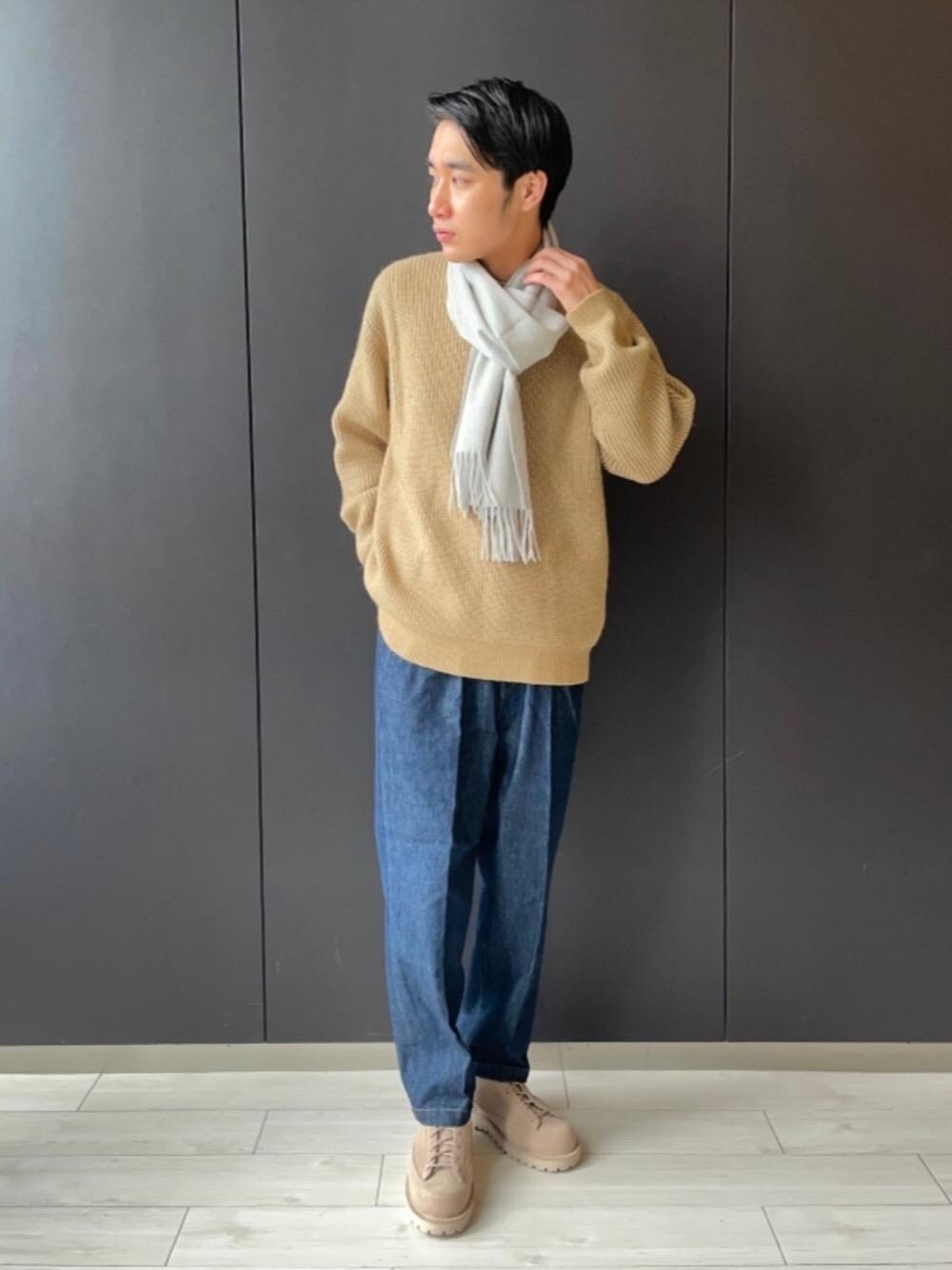 ブルー系のデニムパンツ、ベージュ系のブーツ、ベージュ系のニット/セーターを着用したメンズの冬コーディネートの1枚目の写真