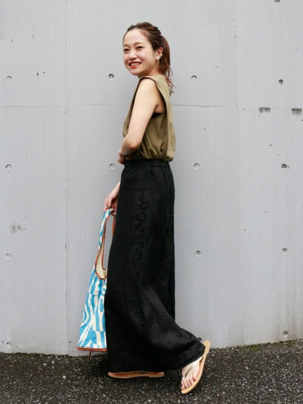 ブラック系のその他パンツ、ゴールド系のサンダル、ブルー系のショルダーバッグを着用したレディースの春コーディネートの1枚目の写真