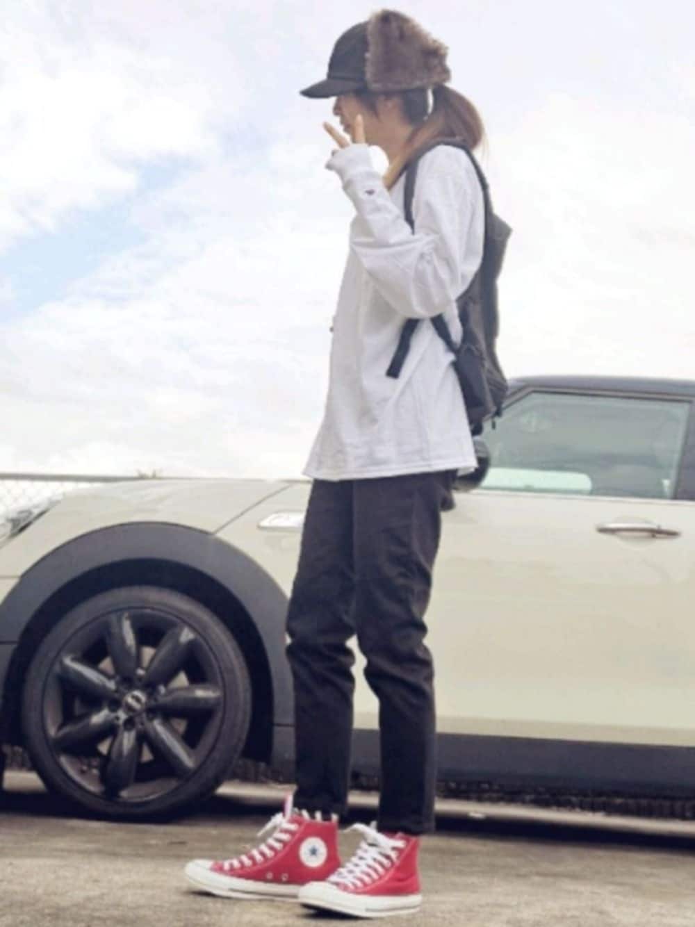 ブラック系のデニムパンツ、レッド系のスニーカー、ホワイト系のTシャツ/カットソーを着用したレディースの秋コーディネートの1枚目の写真