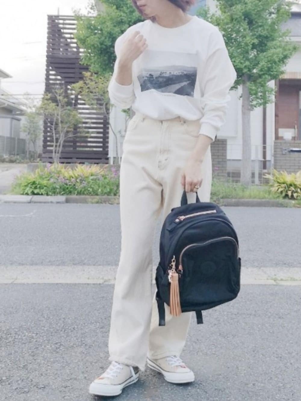 ホワイト系のTシャツ/カットソー、ホワイト系のデニムパンツ、ブラック系のバックパック/リュックを着用したレディースの春コーディネートの1枚目の写真