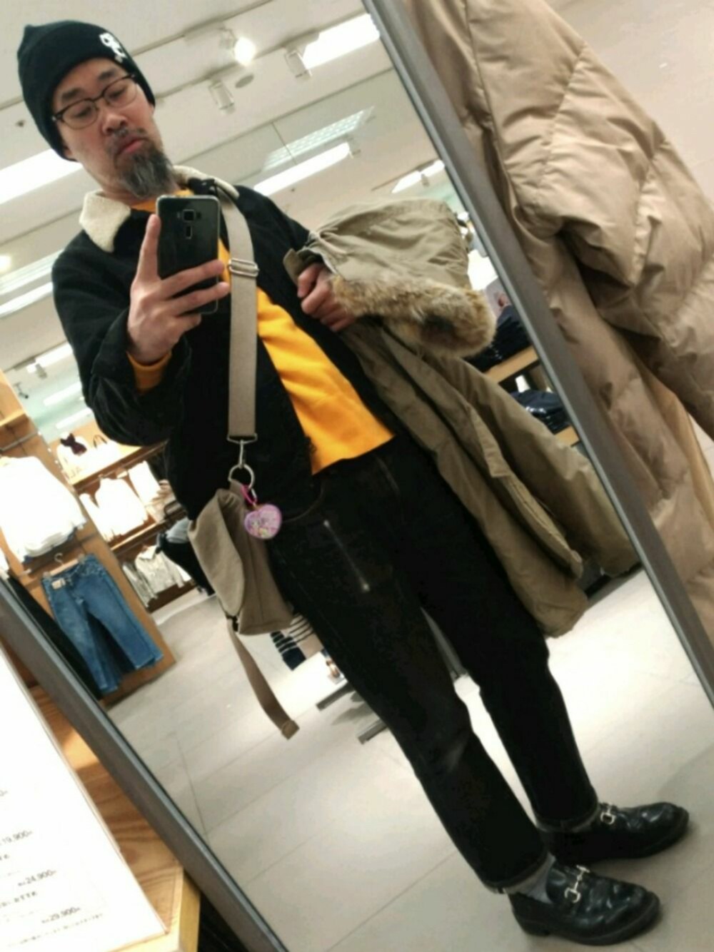 ブラック系のローファー、ベージュ系のミリタリージャケットを着用したメンズの冬コーディネートの1枚目の写真