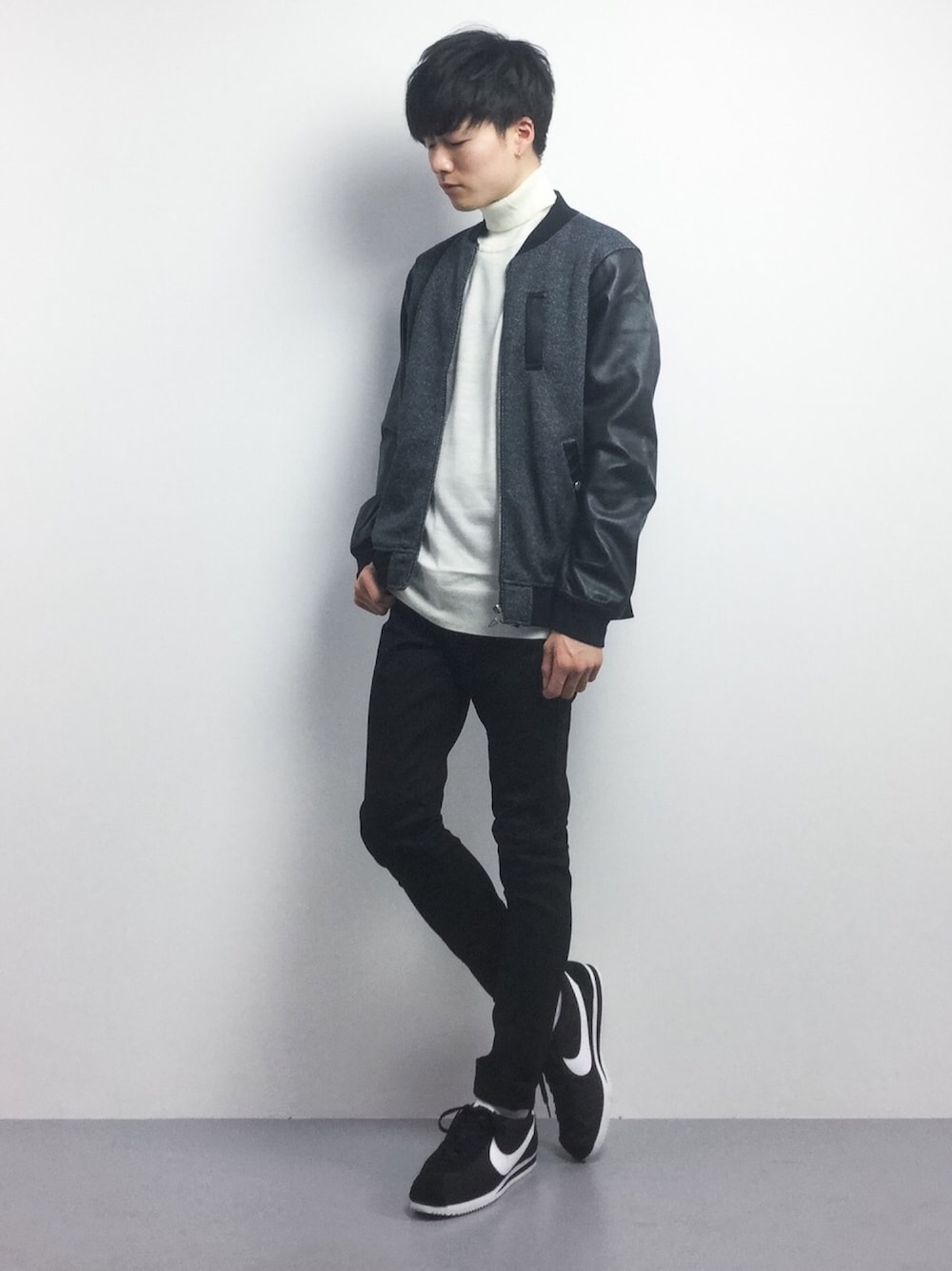 グレー系のMA-1、ホワイト系のニット/セーター、ブラック系のデニムパンツを着用したメンズの冬コーディネートの1枚目の写真