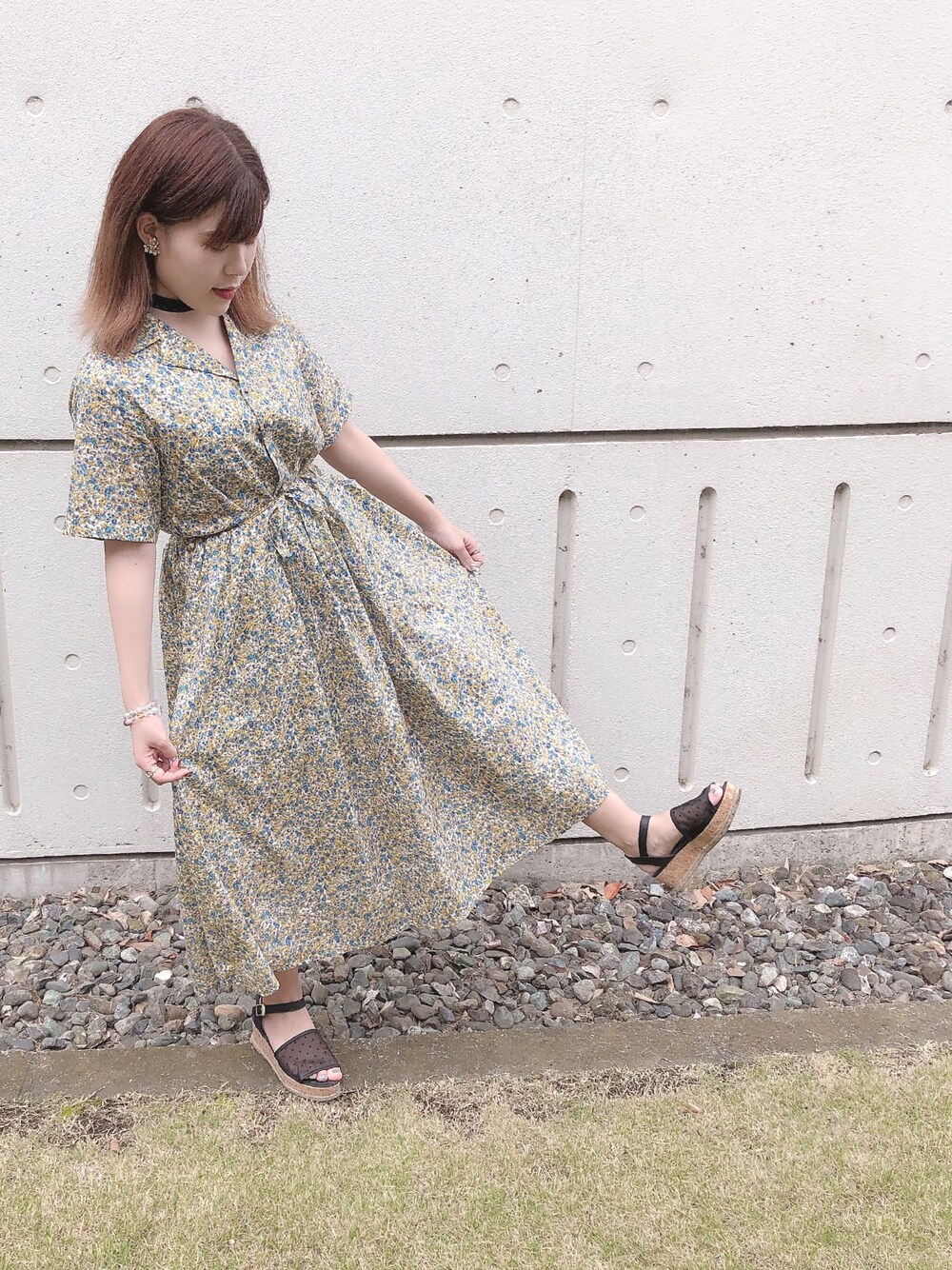 イエロー系のワンピース、ブラック系のサンダルを着用したレディースの夏コーディネートの1枚目の写真