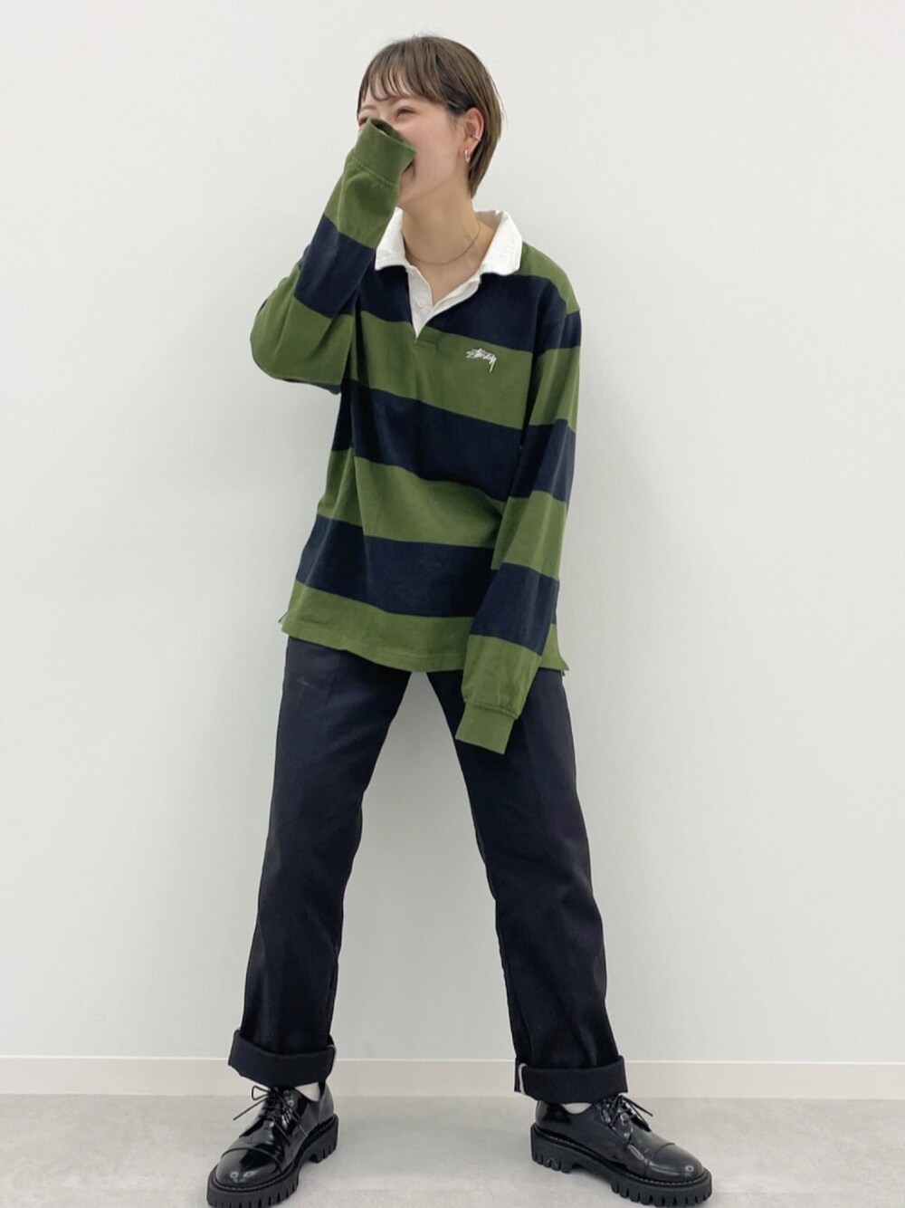 ブラック系のポロシャツ、ブラック系のチノパンツ、ブラック系のシューズを着用したレディースの夏コーディネートの1枚目の写真