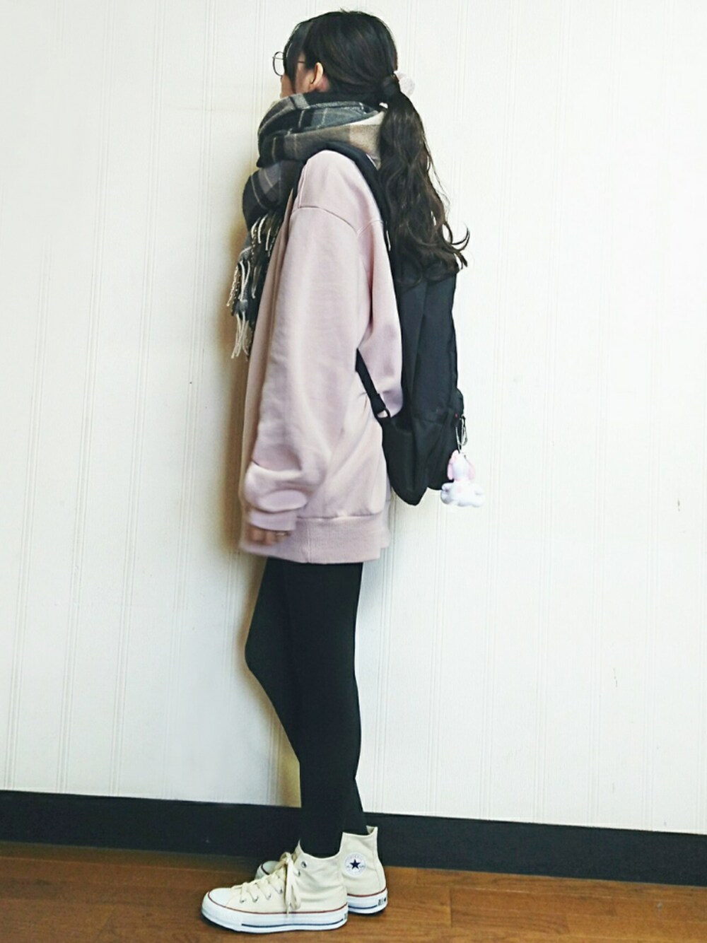 ピンク系のスウェット、ブラック系のバックパック/リュック、ベージュ系のスニーカーを着用したレディースの冬コーディネートの1枚目の写真