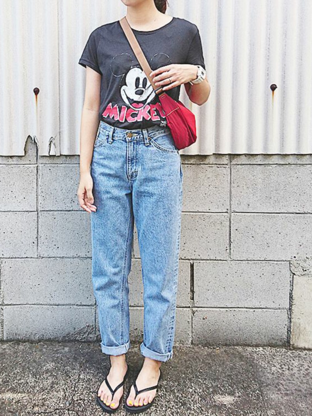 ブルー系のデニムパンツ、ブラック系のTシャツ/カットソー、レッド系のショルダーバッグを着用したレディースの夏コーディネートの1枚目の写真