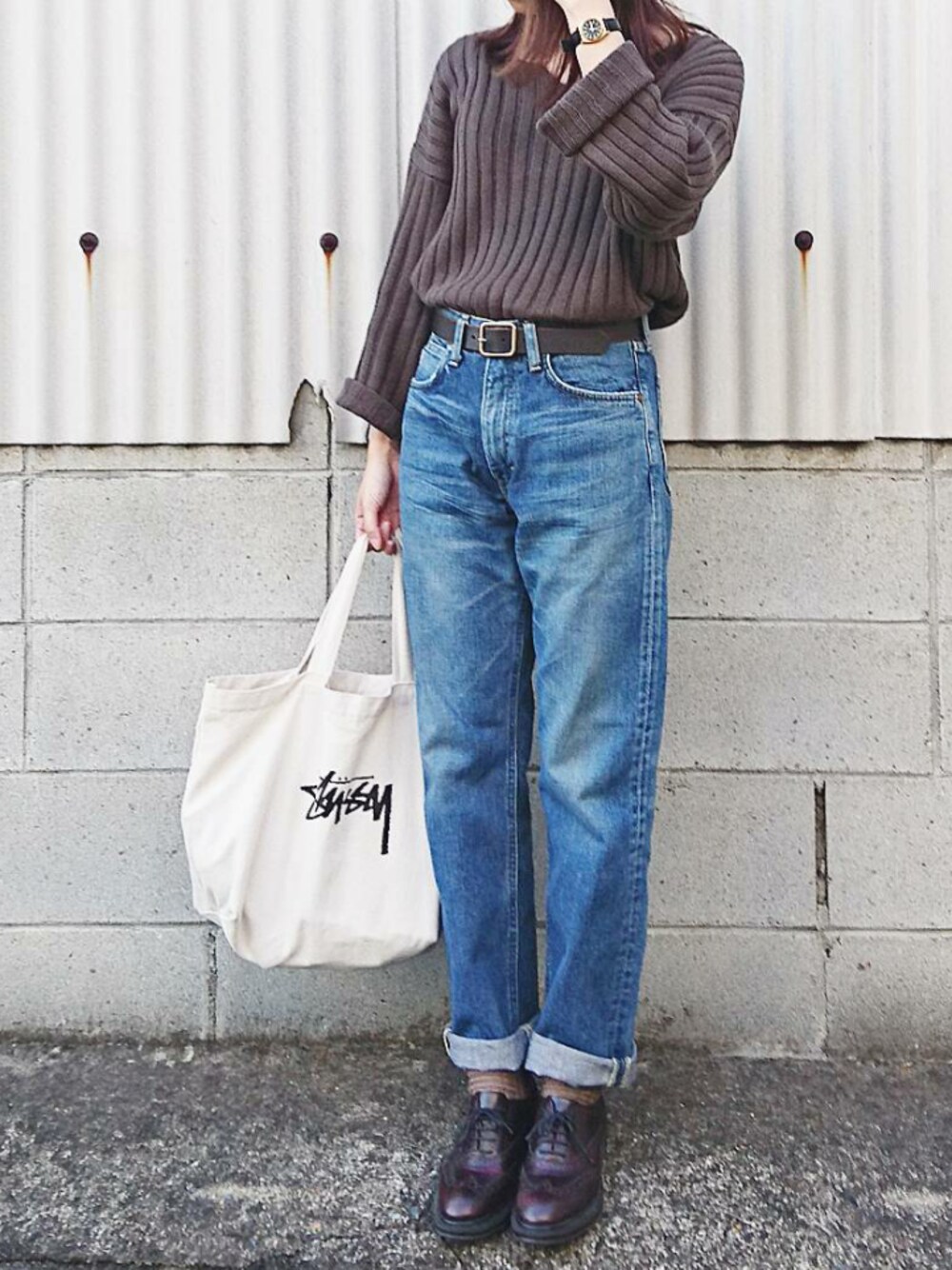 グリーン系のニット/セーター、ブルー系のデニムパンツ、ブラック系のアナログ腕時計を着用したレディースの秋コーディネートの1枚目の写真