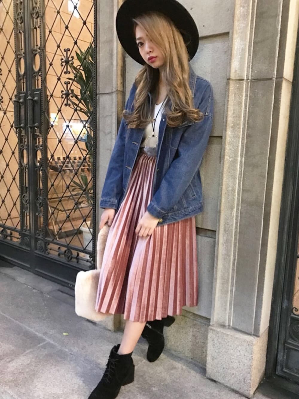 ブルー系のデニムジャケット、ベージュ系のトートバッグ、ピンク系のスカートを着用したレディースの秋コーディネートの1枚目の写真