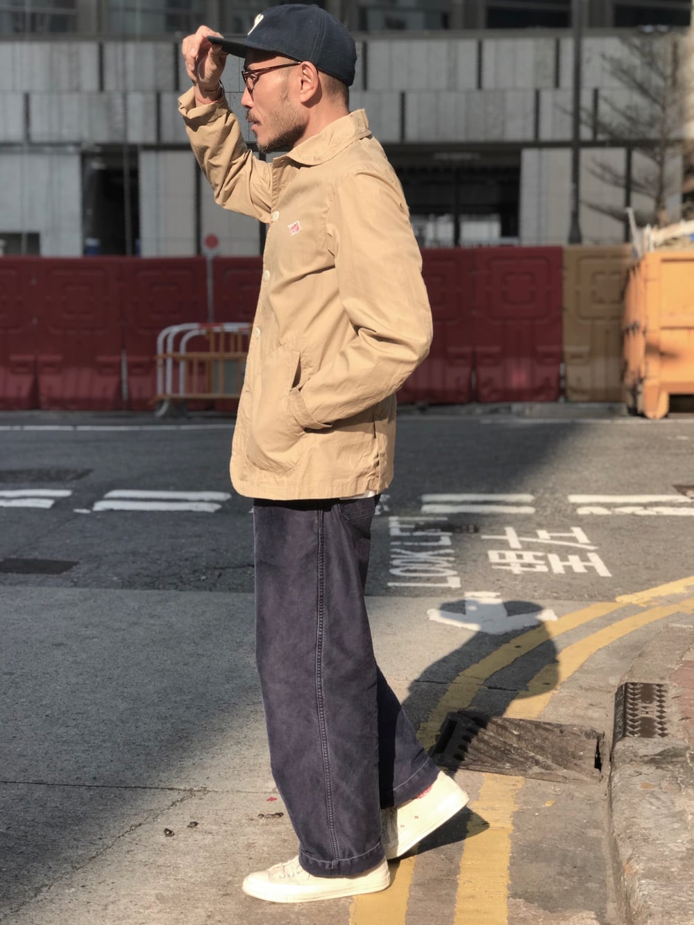 ブラウン系のカバーオール、ブルー系のチノパンツ、ホワイト系のスニーカーを着用したメンズの冬コーディネートの1枚目の写真