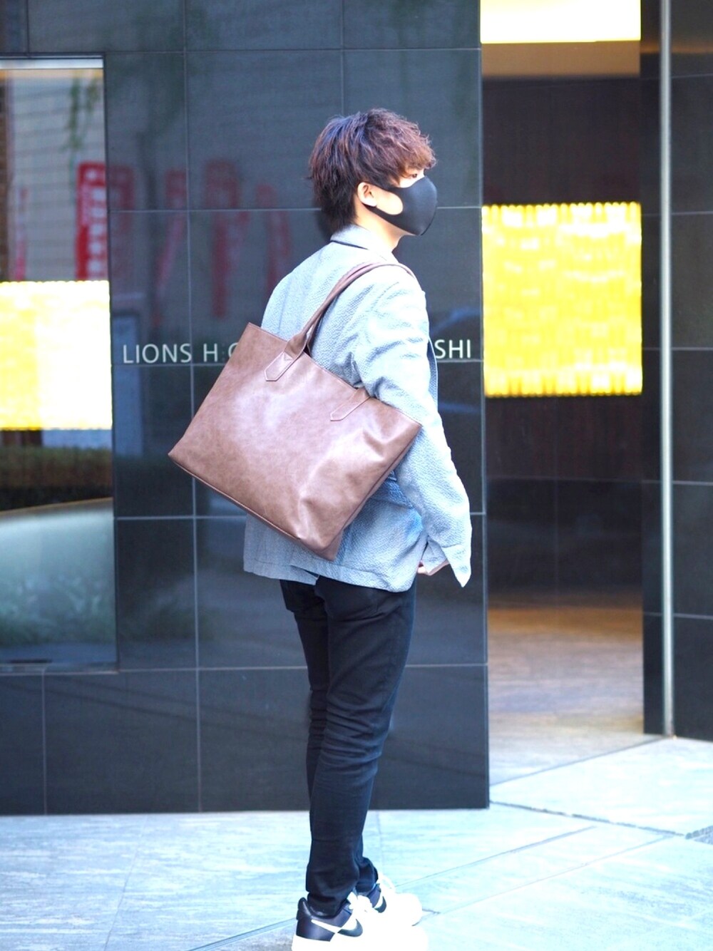 ブラウン系のビジネスバッグ、ブラック系のチノパンツ、その他のスニーカーを着用したメンズの秋コーディネートの1枚目の写真