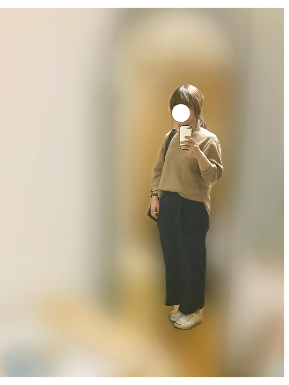 ベージュ系のトップス、ブルー系のパンツ、ホワイト系のスニーカーを着用したレディースの秋コーディネートの1枚目の写真