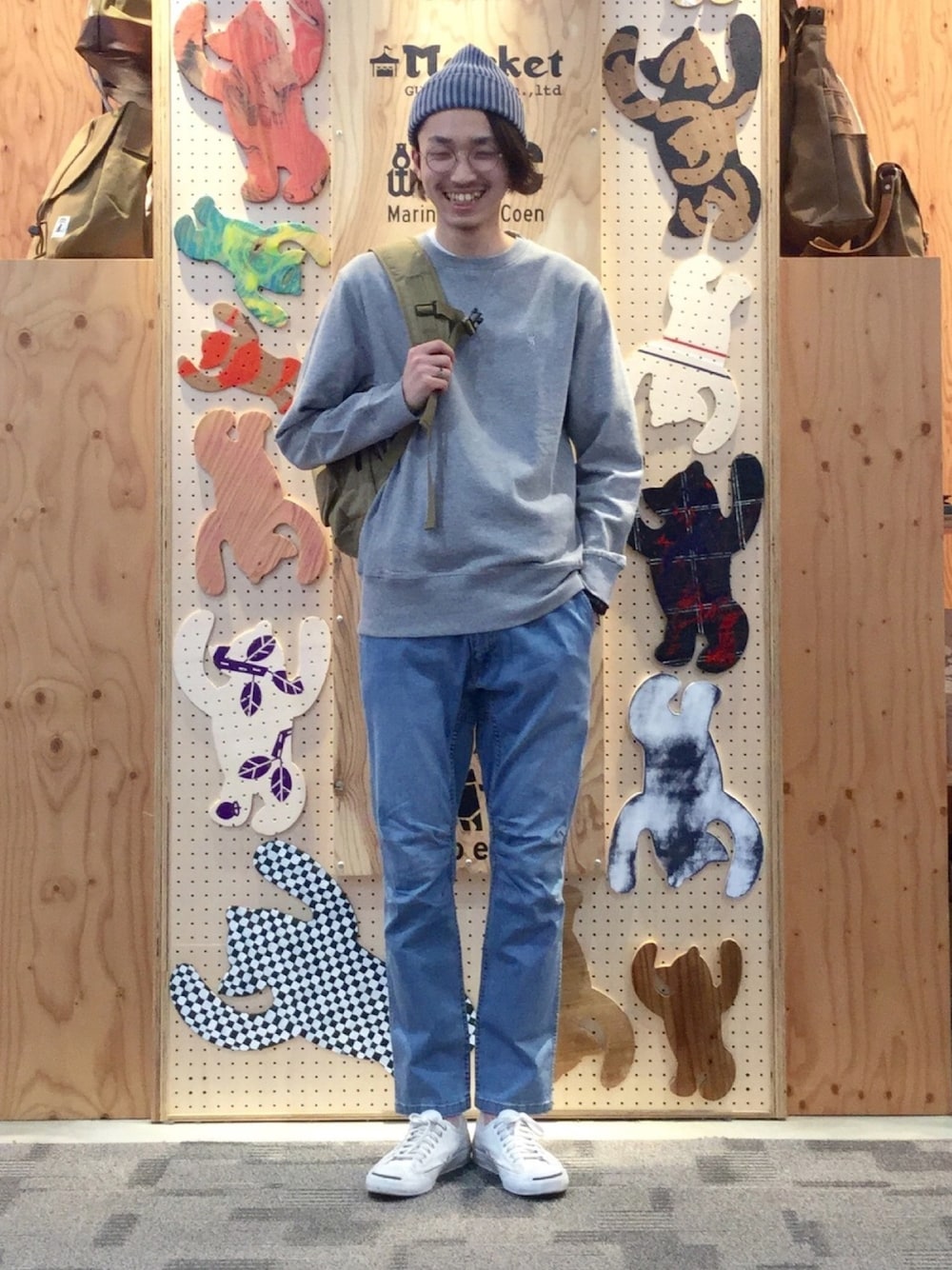 グレー系のスウェット、ベージュ系のバックパック/リュック、ブルー系のデニムパンツを着用したメンズの冬コーディネートの1枚目の写真