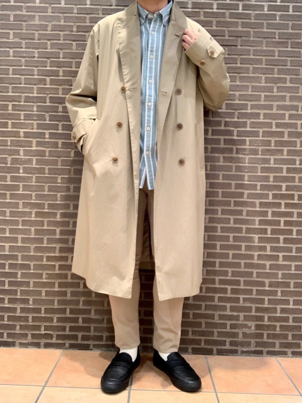 ベージュ系のトレンチコート、ブルー系のシャツ/ブラウス、ベージュ系のその他パンツを着用したメンズの冬コーディネートの1枚目の写真