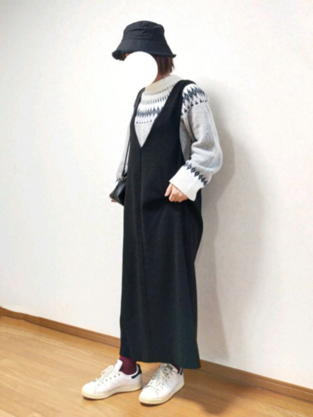 グレー系のワンピース、グレー系のニット/セーター、ホワイト系のスニーカーを着用したレディースの冬コーディネートの1枚目の写真