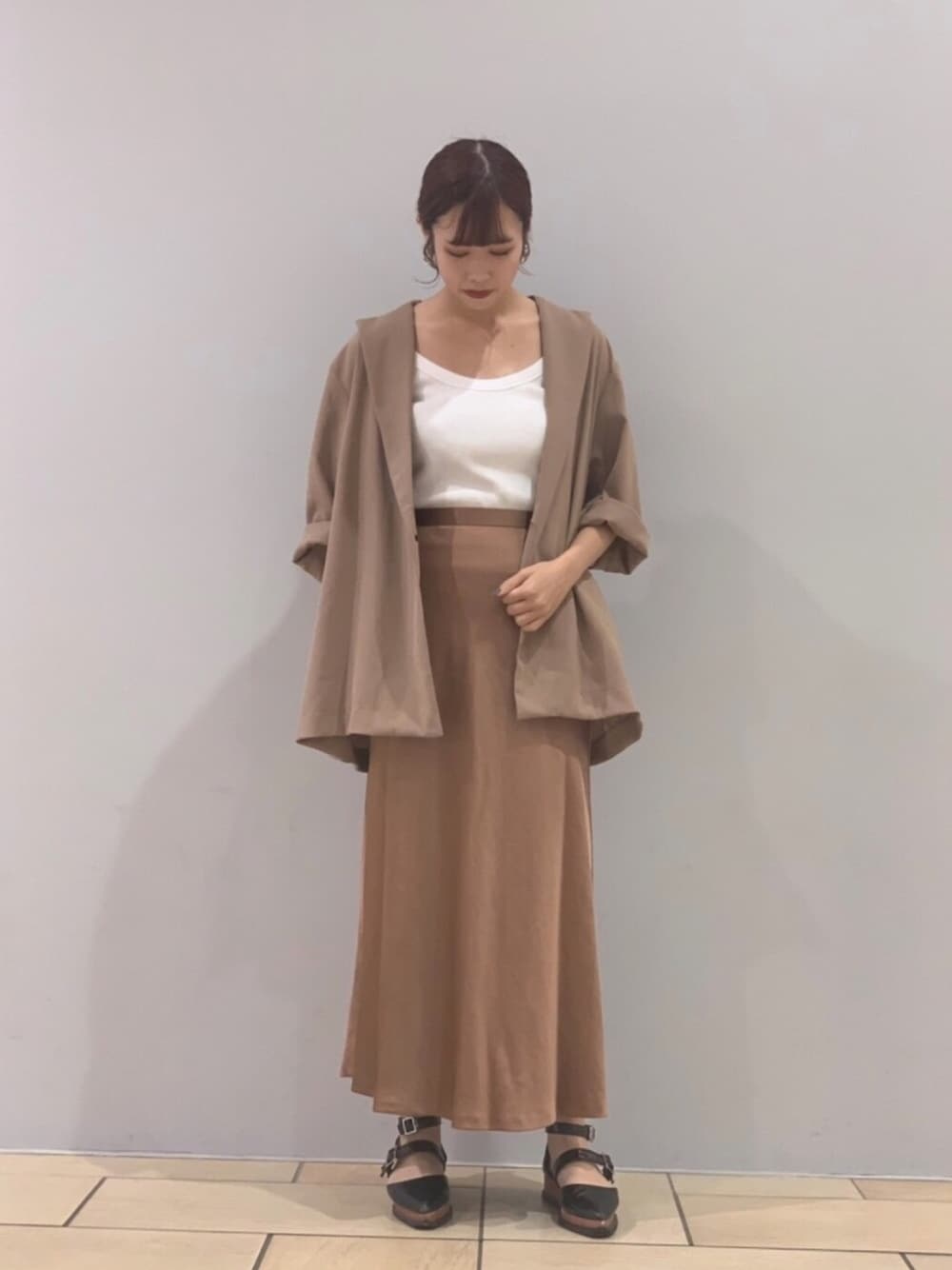 ベージュ系のテーラードジャケット、ベージュ系のスカート、ホワイト系のトップスを着用したレディースの夏コーディネートの1枚目の写真