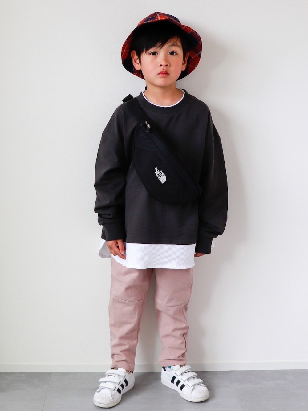 ブラック系のTシャツ/カットソー、ピンク系のスウェットパンツ、ホワイト系のスニーカーを着用したキッズの春コーディネートの1枚目の写真
