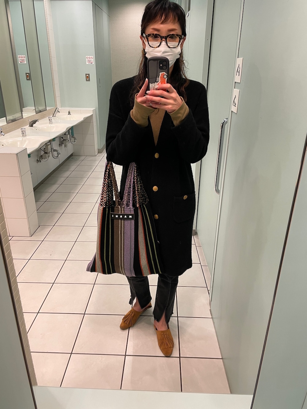 ブラック系のカーディガン/ボレロ、ベージュ系のパンプス、その他のトートバッグを着用したレディースの春コーディネートの1枚目の写真